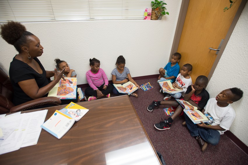 Principal Cassandra Smith works on reading with second grade students in her office at Lincoln Park Primary School. Photo credit: Michael Spooneybarger