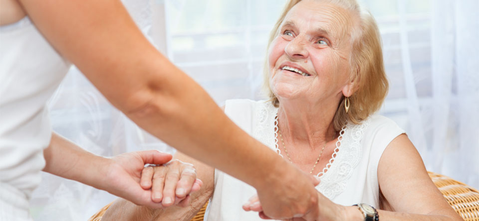 image of woman helping elderly smiling lady