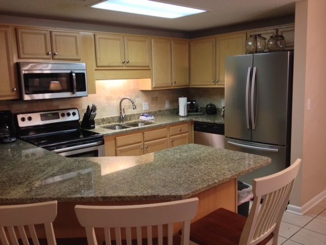 Spacious kitchen with granite counter top and breakfast bar with seating for three