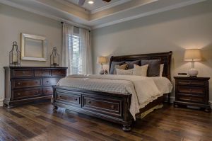 image of a bedroom with brown furniture and cream linens