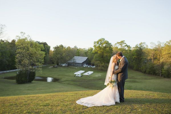 An image of a bride and groom kissing on a hill