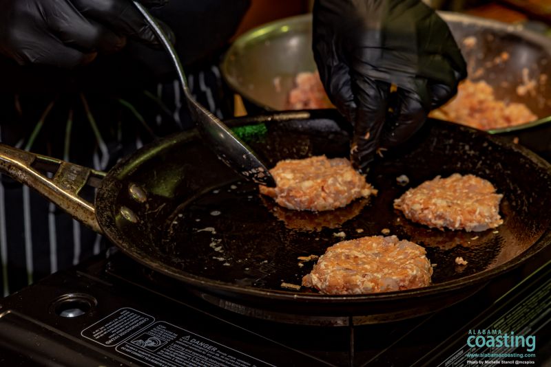 Close-up of crab cakes being sauteed in skillet