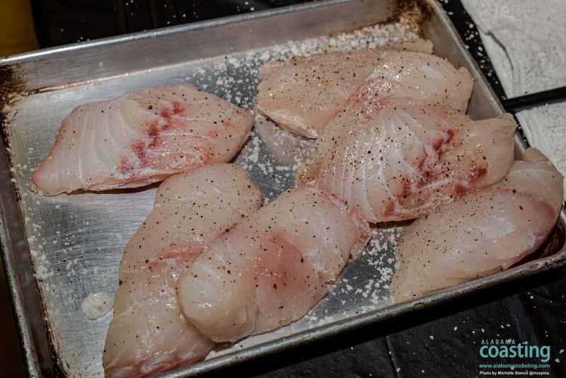 seasoned fish filets resting on baking sheet ready to be cooked