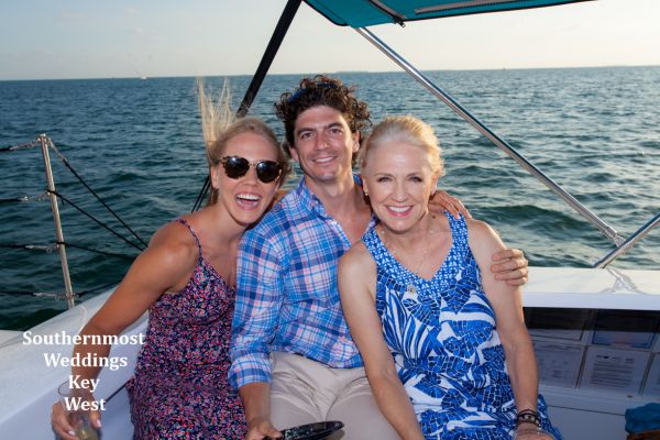 Wedding party pose for photos during their private sunset sailboat reception after their beach wedding by Southernmost Weddings Key West