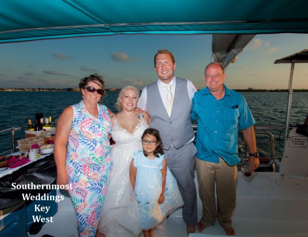 Wedding party pose for photos during their private sunset sailboat reception