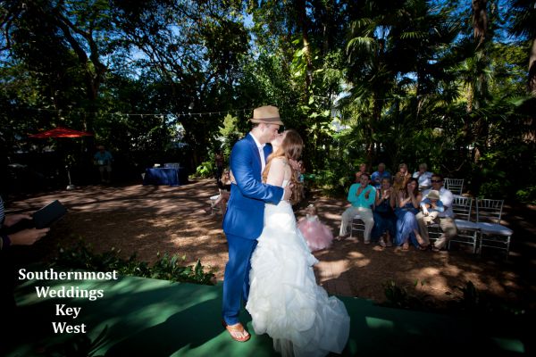 Wedding couple kisses after getting married at the Hemingway Home by Southernmost Weddings