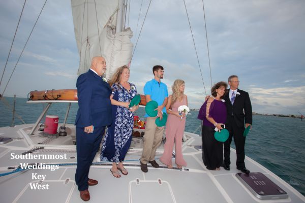 Wedding party watches the ceremony on a private sunset sailboat off the coast of Key West, Fl.