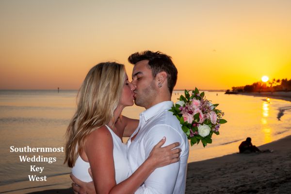 Wedding couple kisses after being married by Southernmost Weddings Key West on Smathers Beach 