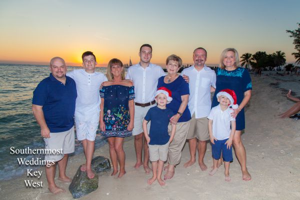 Family poses for photos on the beach at sunset by Southernmost Weddings Key West