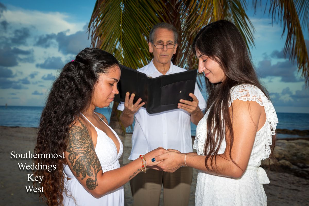 Wedding officiant performs a ceremony for two women on Smathers Beach in Key West, Florida