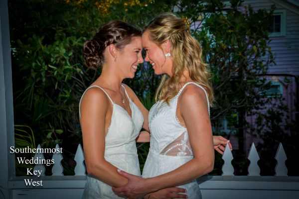 Two brides poses for photos before the wedding in a historic Key West Tropical Garden