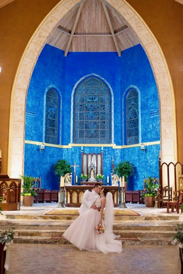 Bride and groom kissing at the altar
