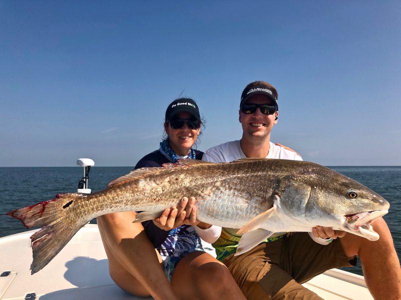 Man And Woman Holding Large Redfish 