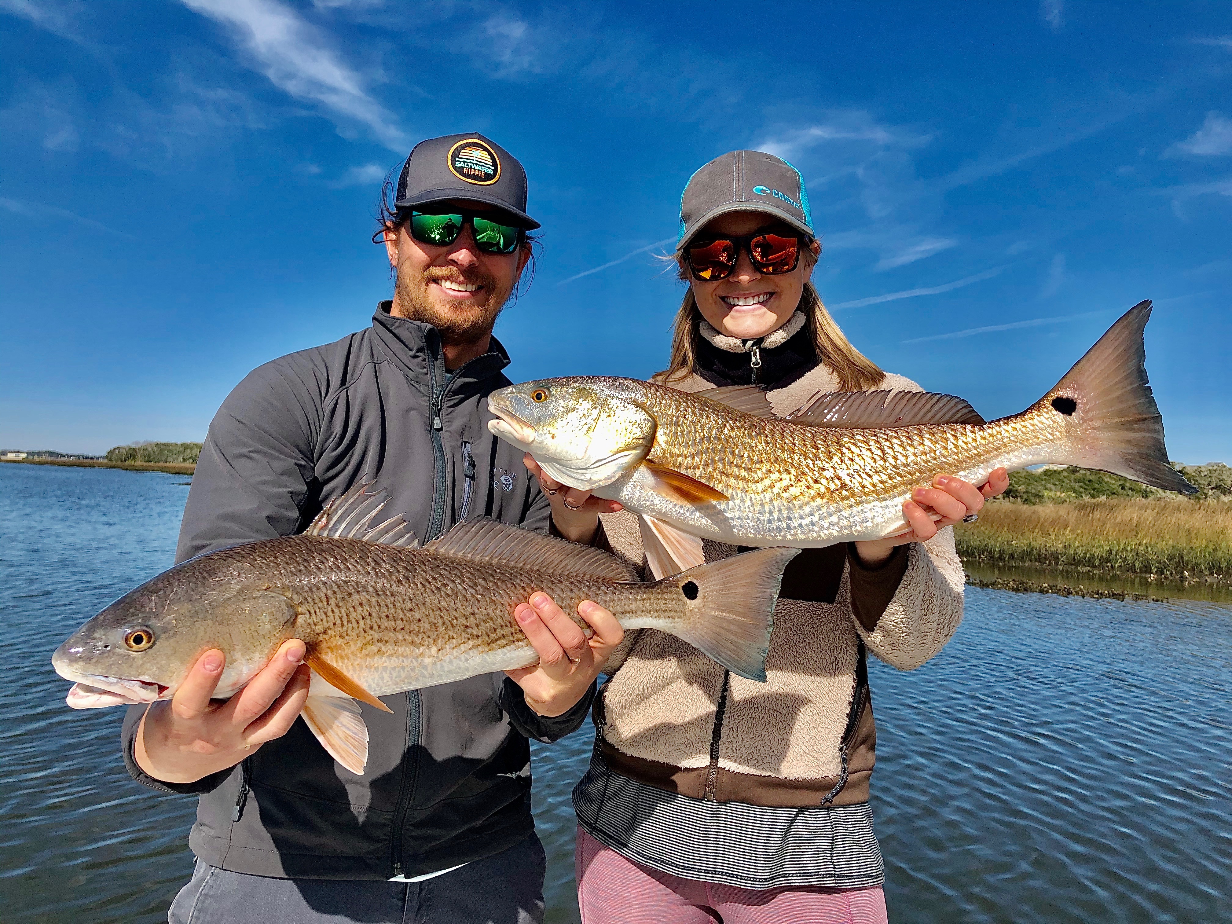 Lady And Man Holding Redfish
