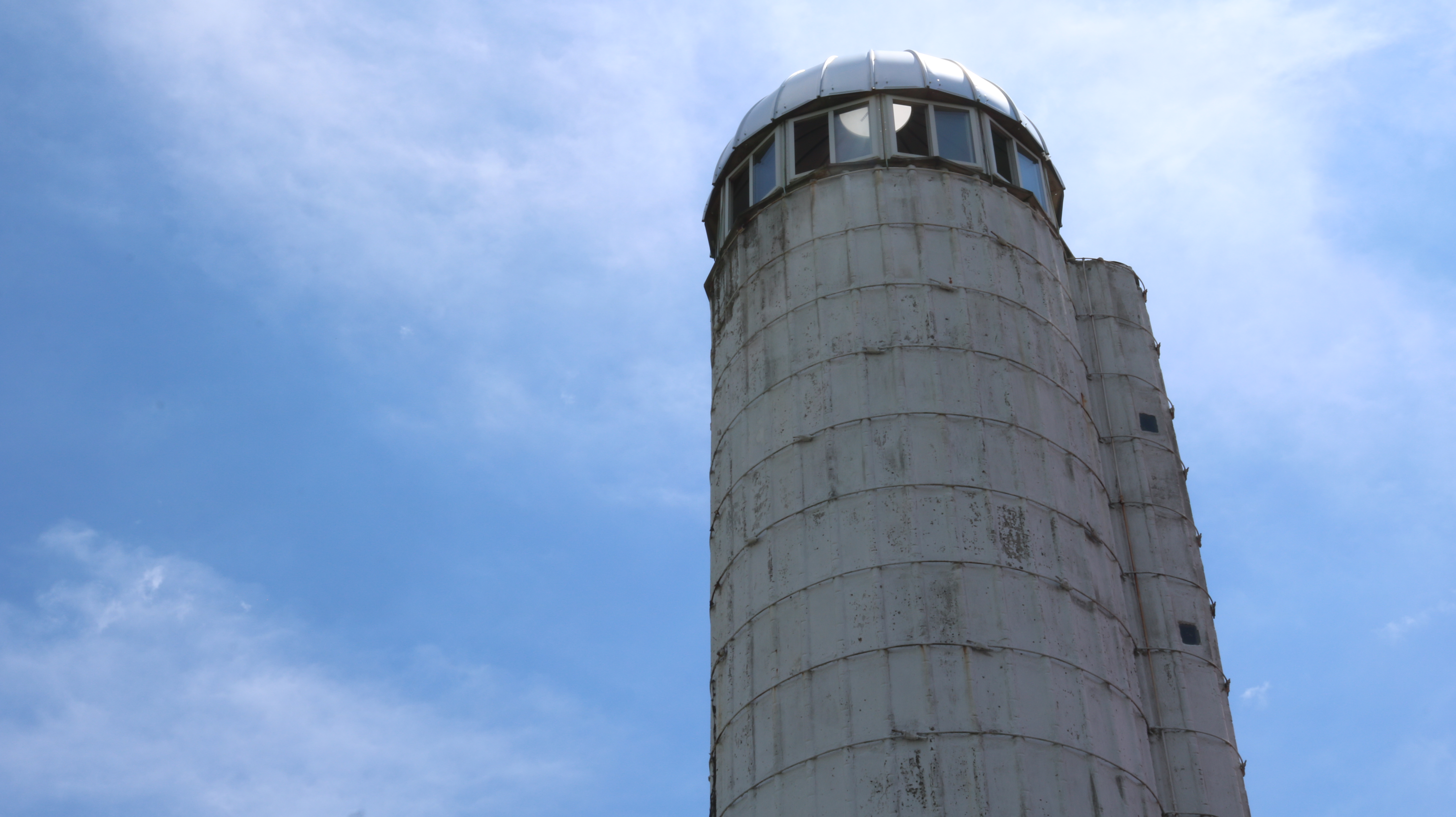 an old bar silo against a bright blue sky