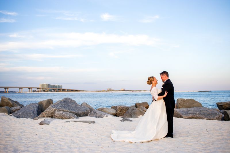 bride and groom embracing on beach