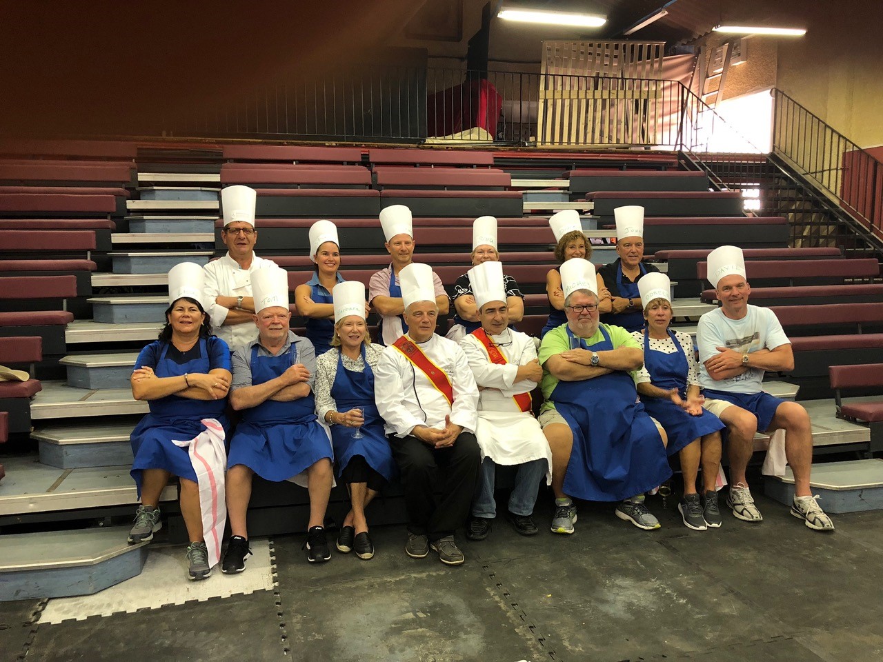 Guests posing with chefs in chef outfits