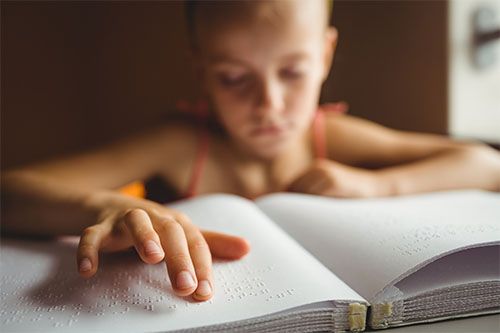 image of a child reading braile