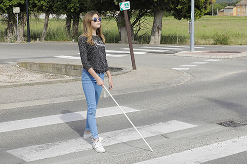 image of blind girl crossing the road usinga cane