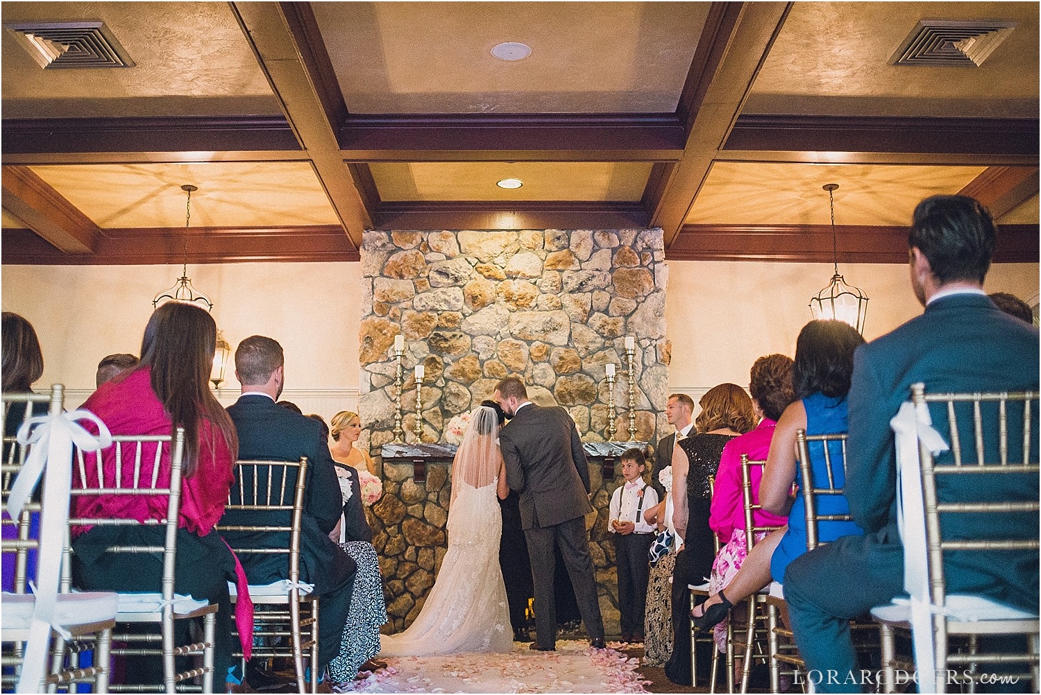 bride and groom standing at fireplace