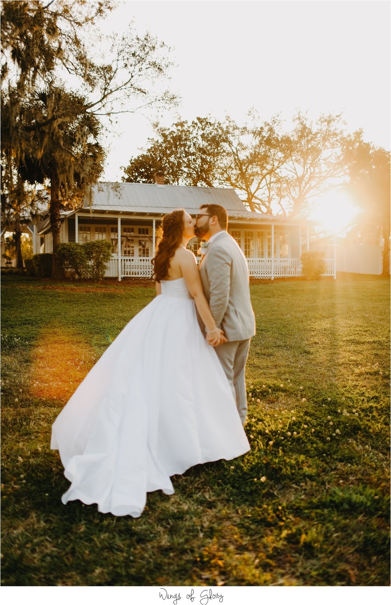 bride and groom kiss during sunset