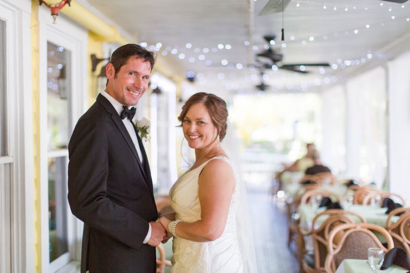 Bride and groom posing for a picture on a porch