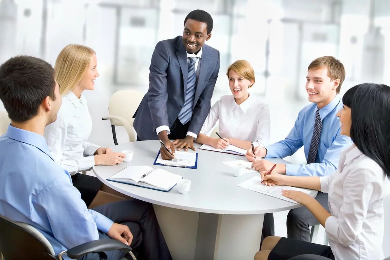 Group of professionals in an office gathered around a table having a meeting