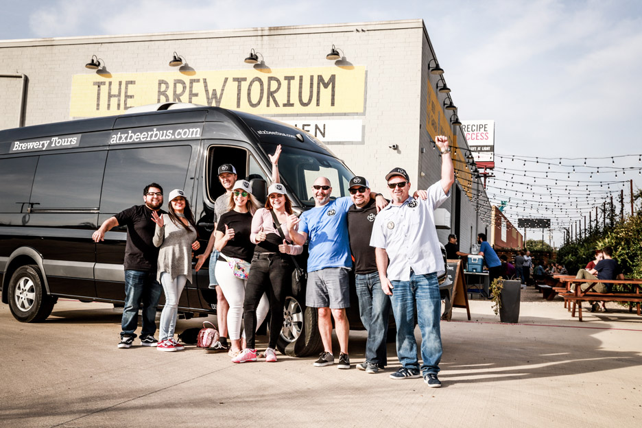 ATX Beer Bus riders cheering in front of vehicle and brewery 
