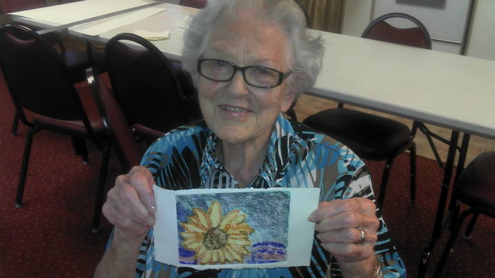 Senior holding up floral artwork