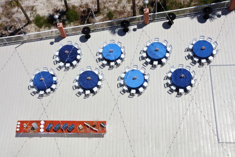 aerial view of outdoor deck featuring tables with blue tablecloths