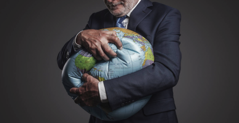 Image of a man squeezing an inflatable World Globe